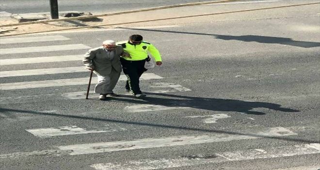Polis, yürümekte zorluk çeken yaşlı adamı kolundan tutarak karşıya geçirdi